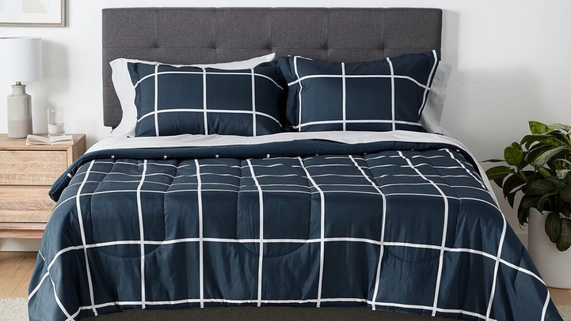 Navy plaid bedding set with white grid lines shown on a full-size bed with pillows and a comforter.