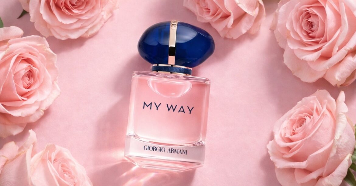 Armani Beauty My Way perfume bottle with a blue and gold cap, displayed on a soft pink background surrounded by blush roses, showcasing the elegant floral fragrance design.