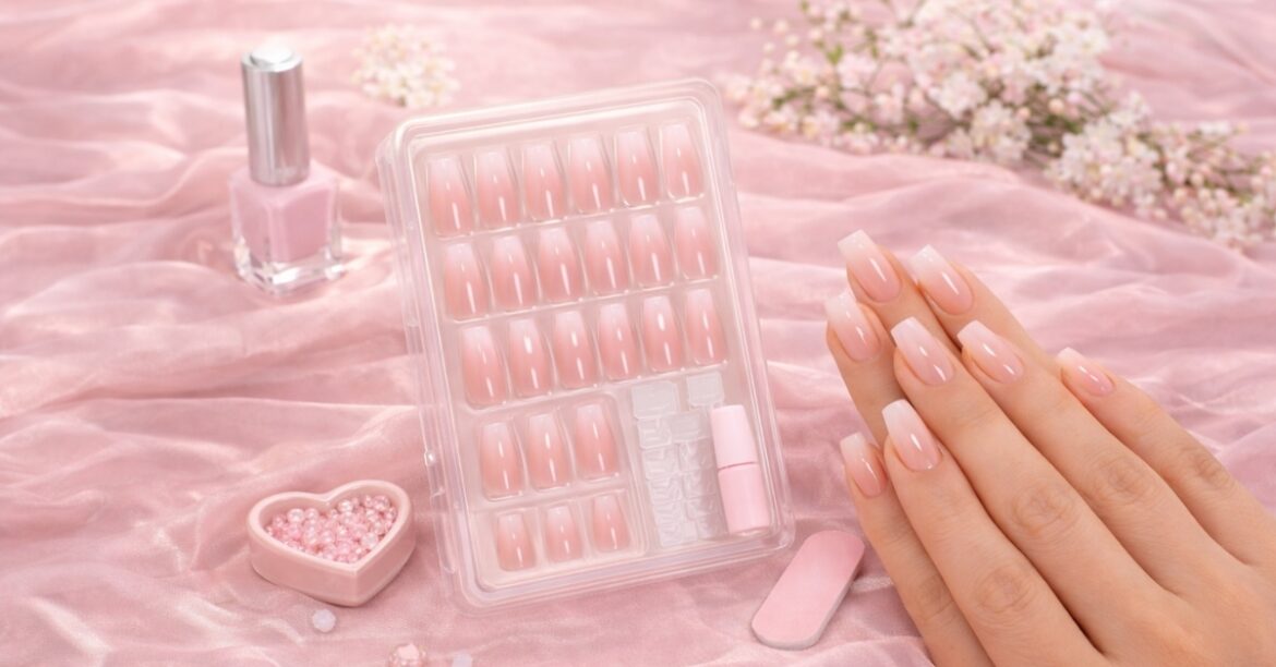 Gradient pink press-on nails kit with glossy ombré nails and manicure accessories on soft pink background