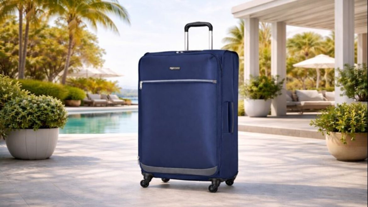 Amazon Basics 28-Inch Expandable Softside Suitcase in navy blue with spinner wheels standing by a luxury poolside patio.